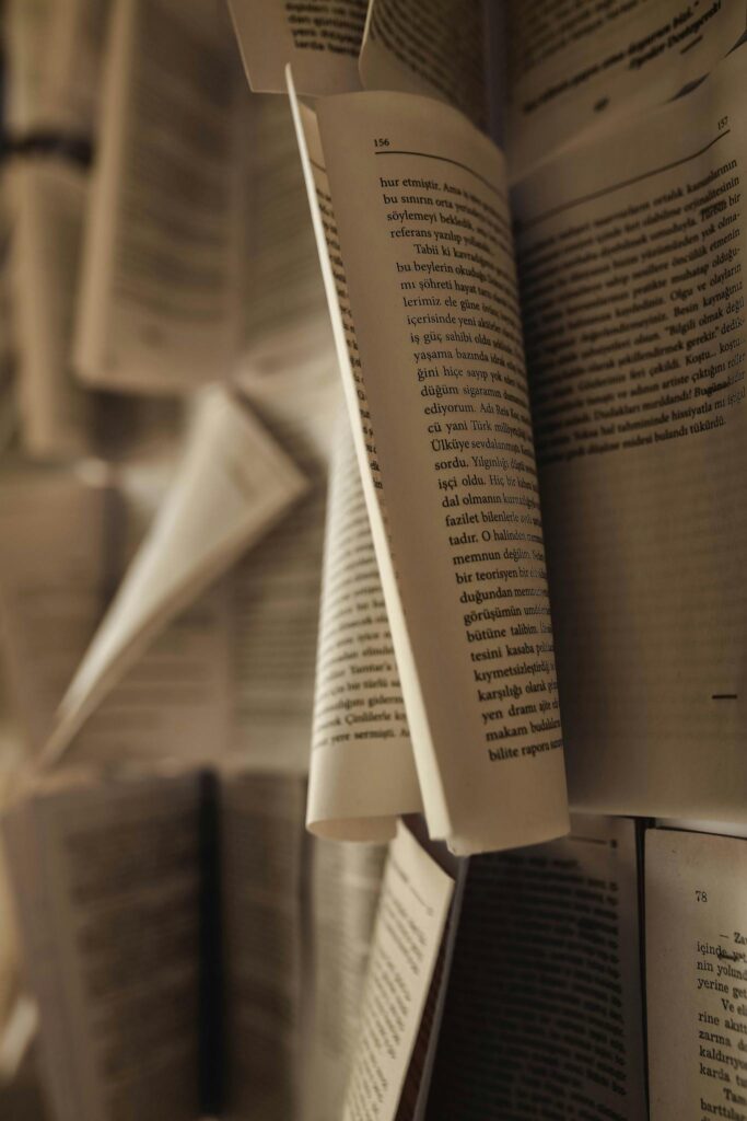 Artistic close-up of open book pages in motion, highlighting the texture and depth of paper.